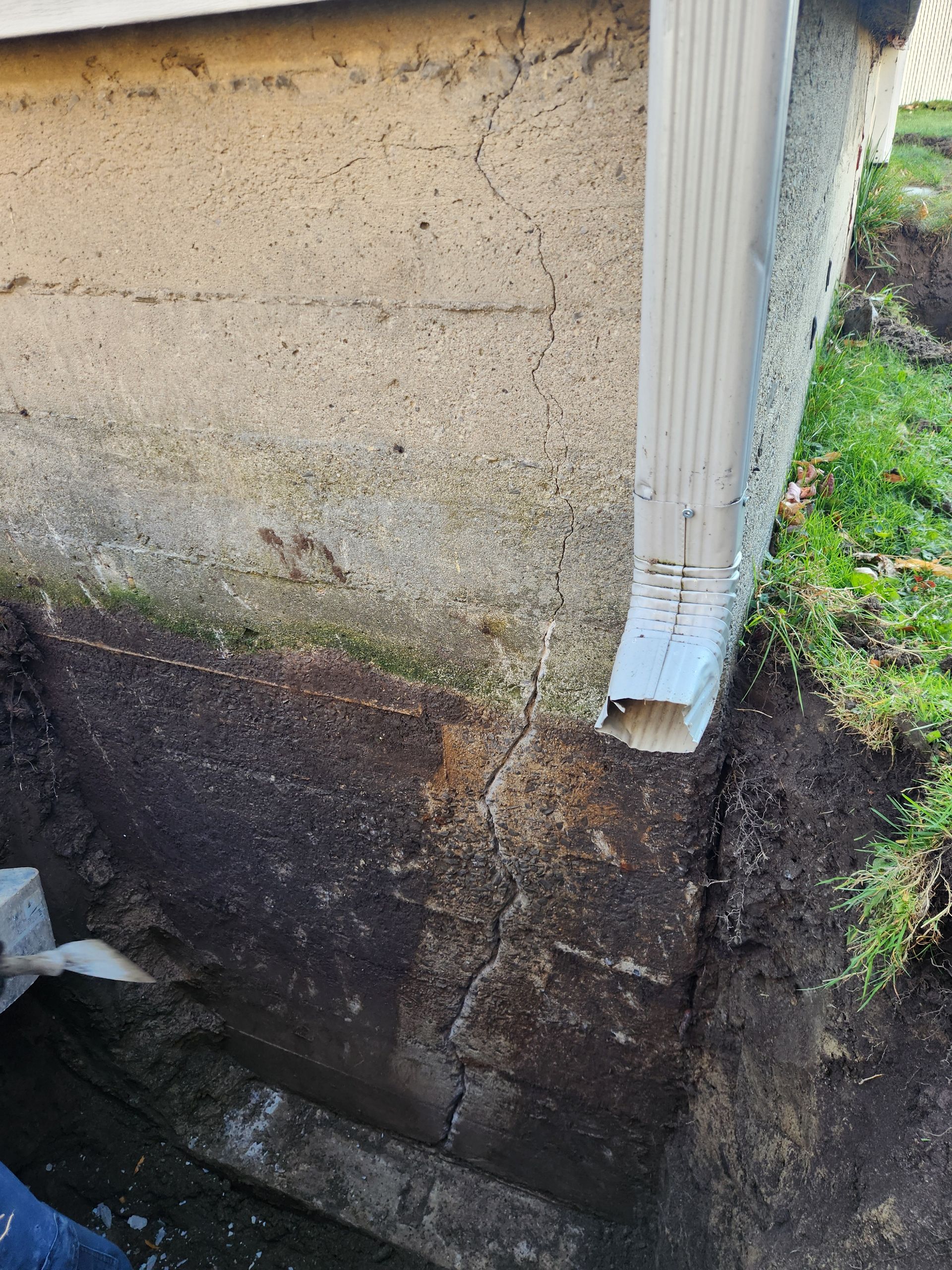 Une personne creuse un trou dans le sol à côté d'une maison.