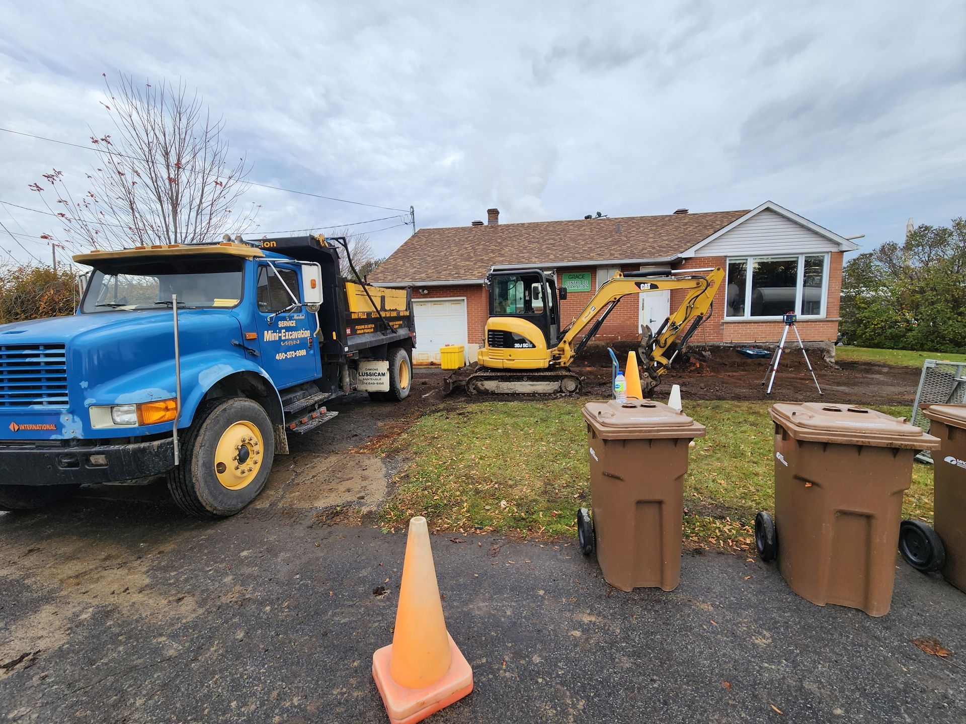Une dépanneuse bleue est garée devant une maison.
