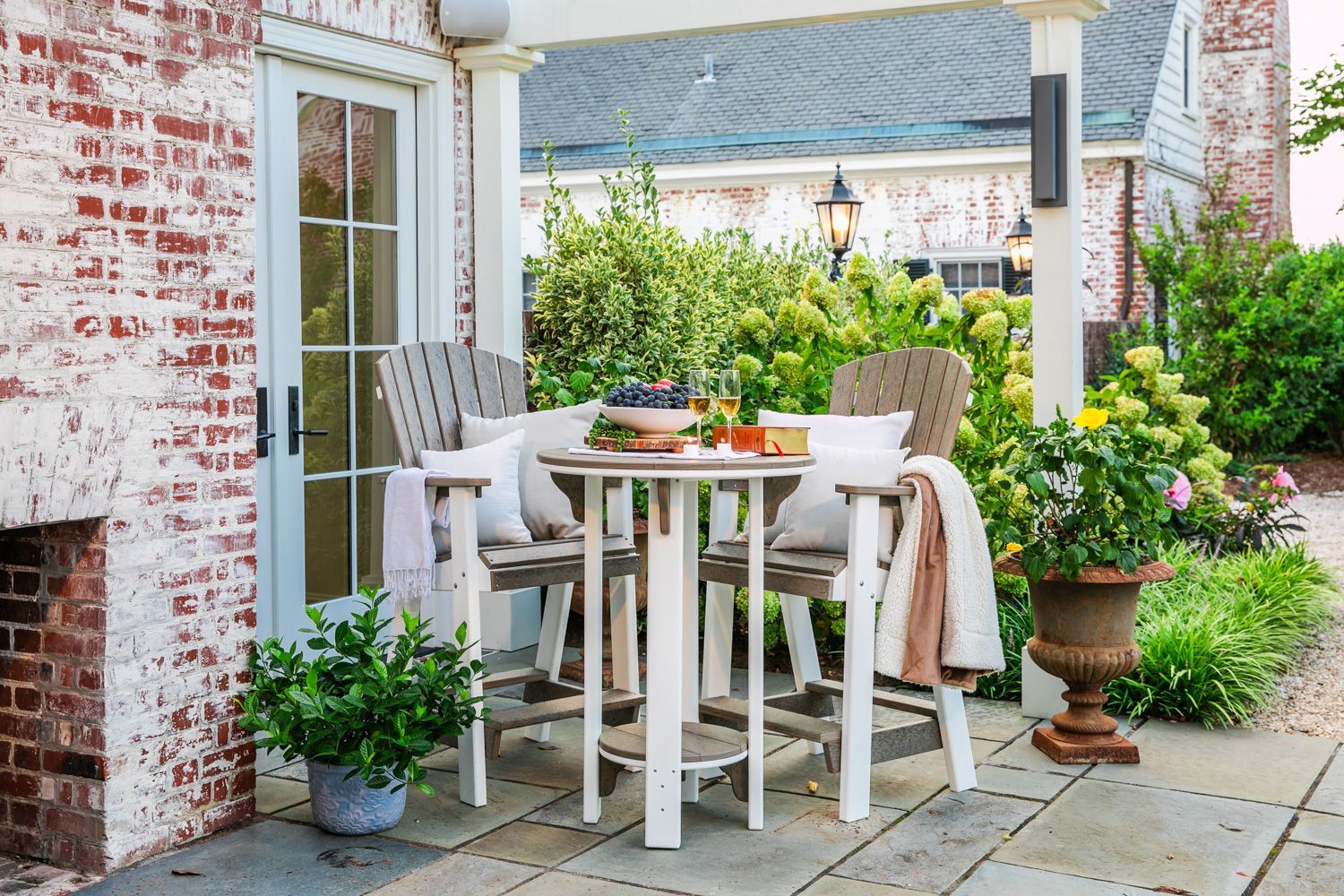 A patio with a table and chairs in front of a brick building.