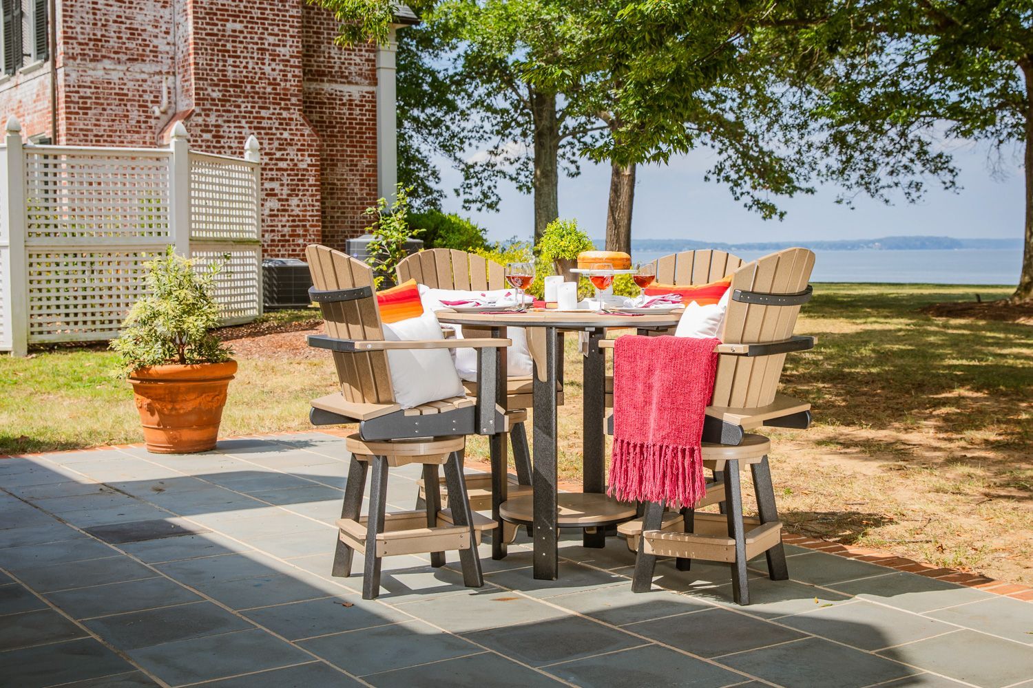 A table and chairs on a patio with a view of the ocean.