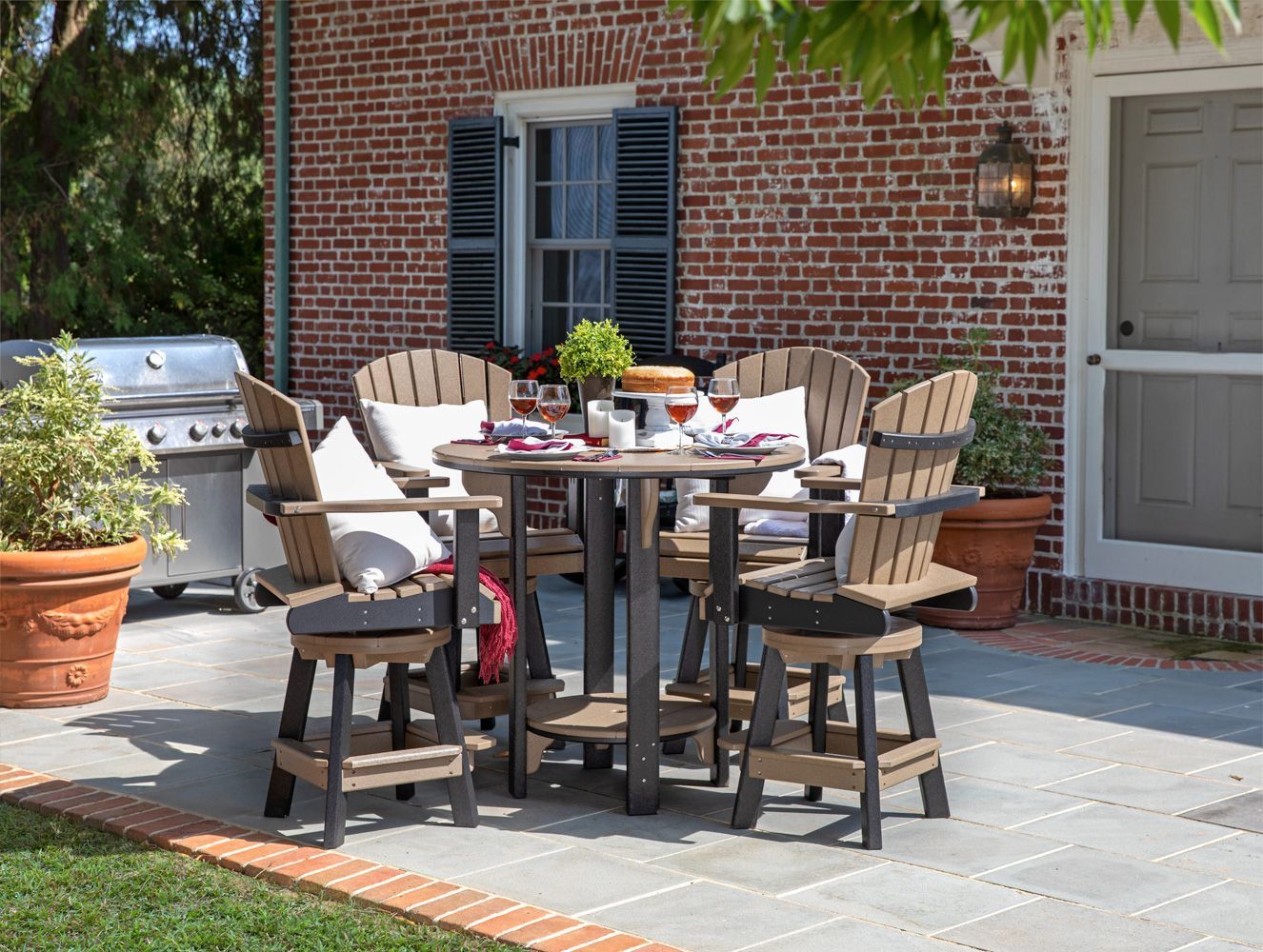 A patio with a table and chairs in front of a brick building.