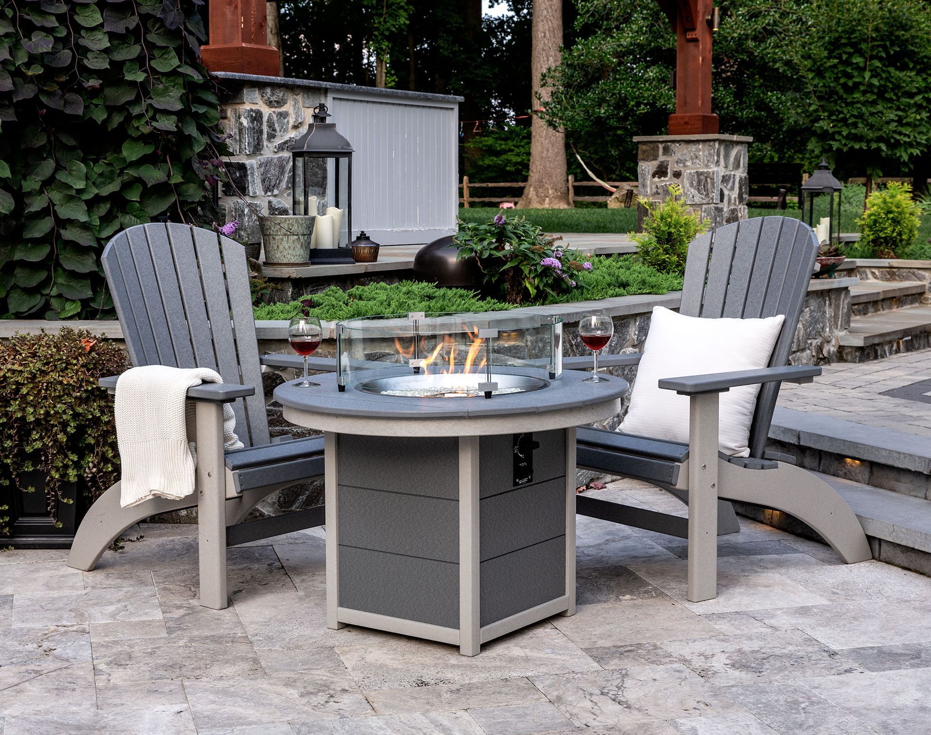Two chairs are sitting around a fire pit on a patio