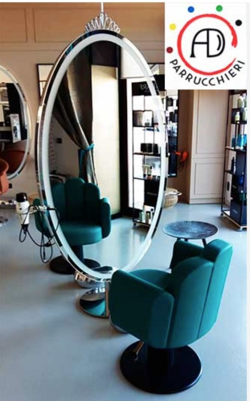 Un salone da parrucchiere con un grande specchio e sedie verdi