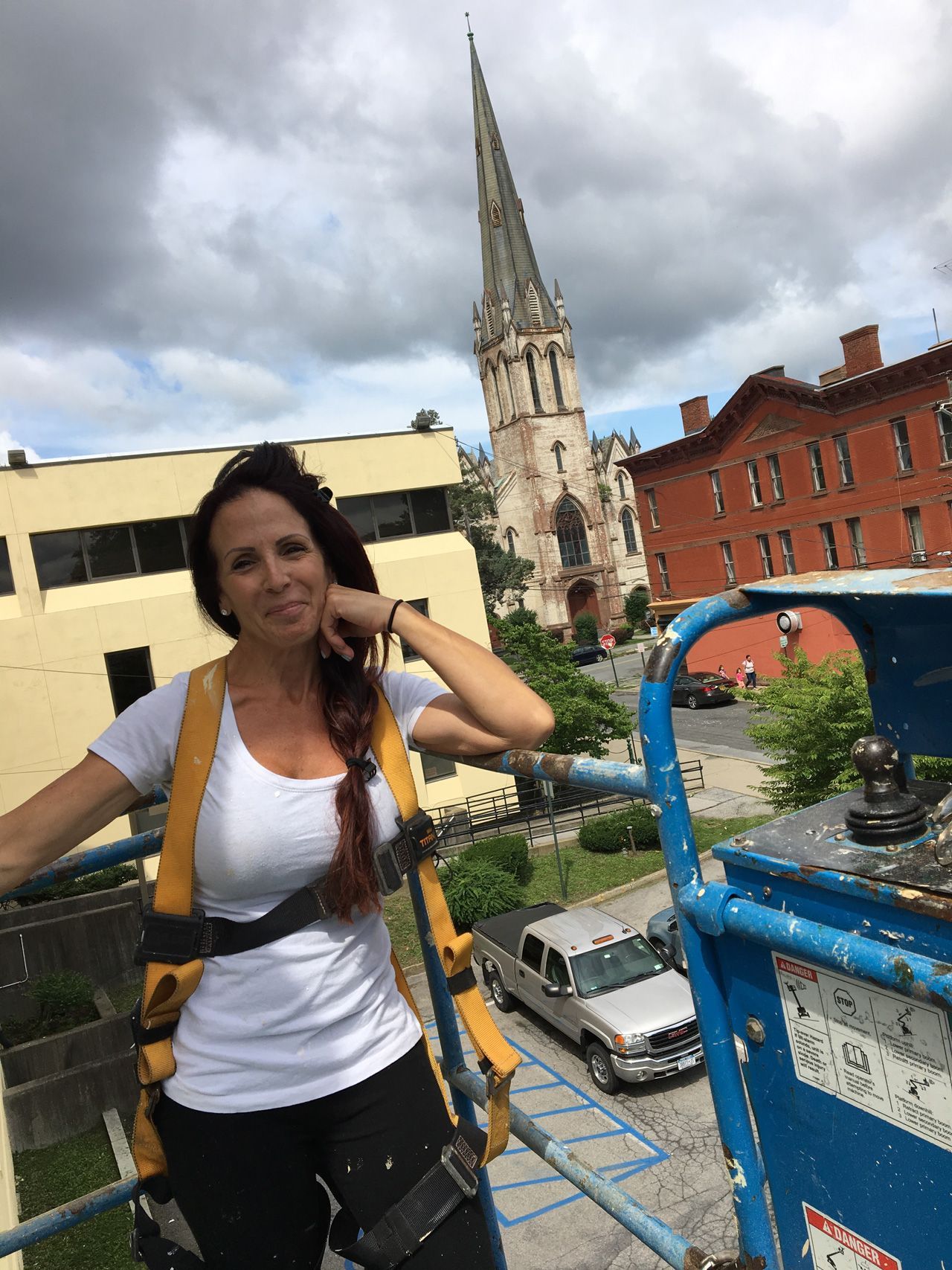 A brush is sitting on top of a pile of paint cans.