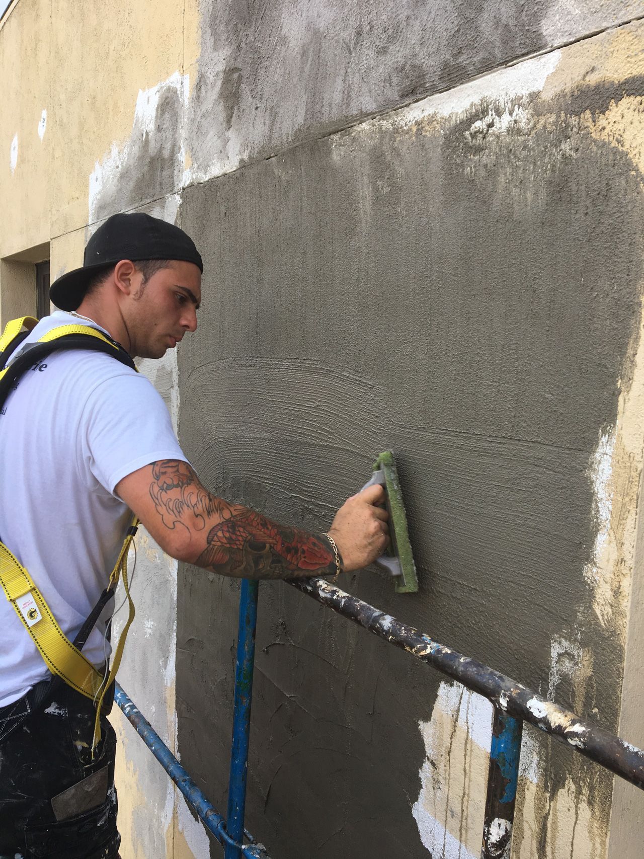 A man is working on a wall with a brush.