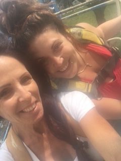 A woman is standing on a crane with a church in the background.