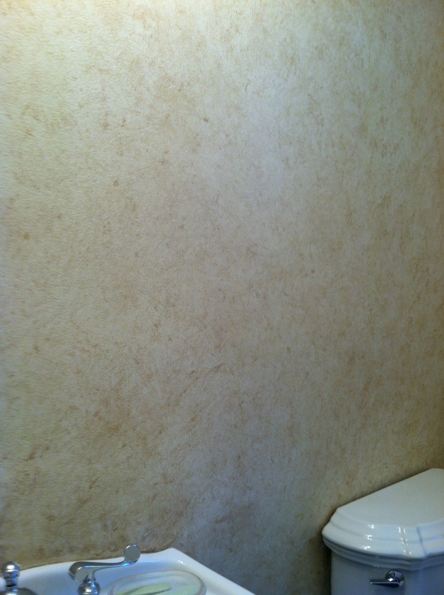 A bathroom with a toilet , sink and mirror.