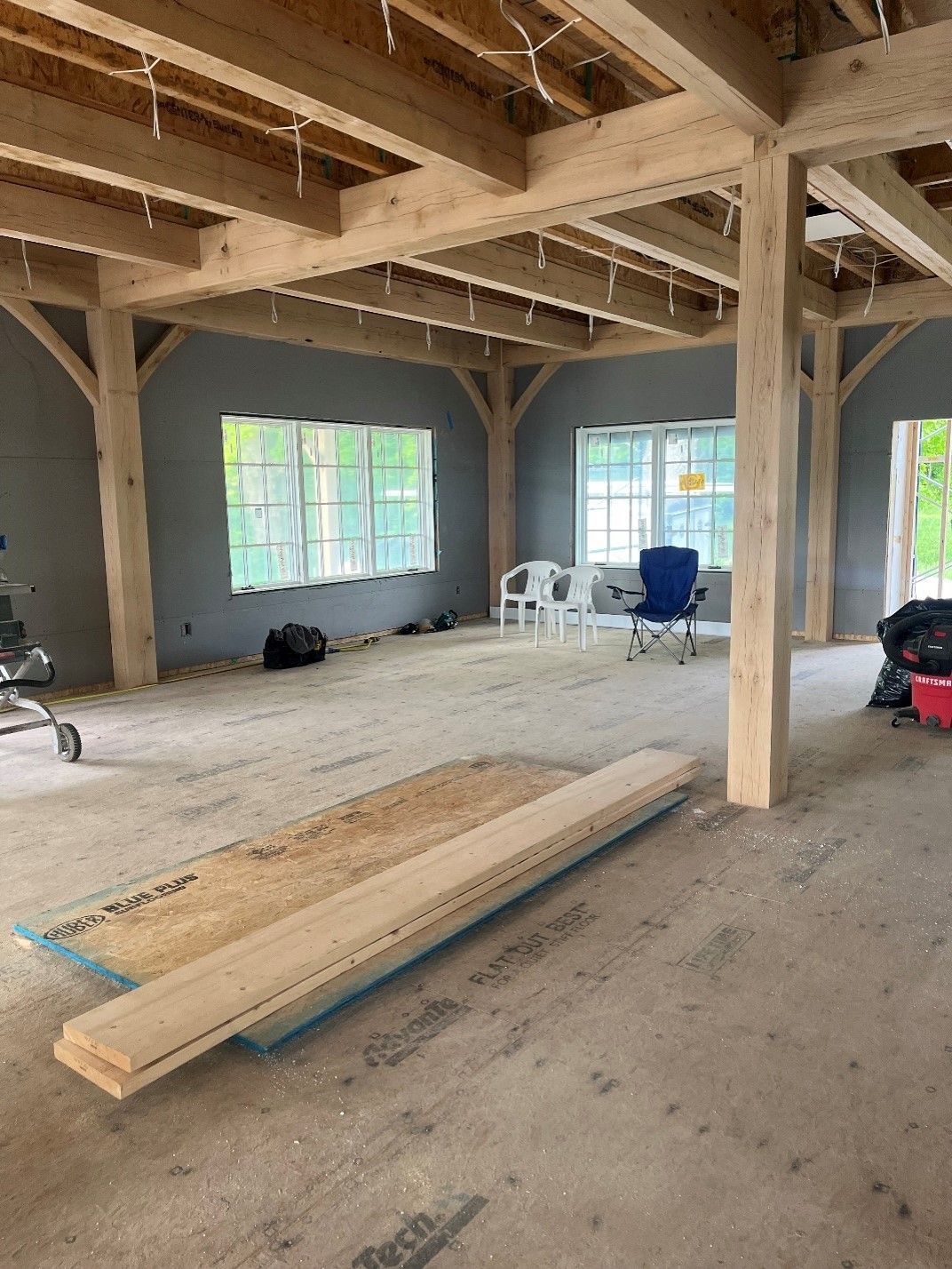 A large room with wooden beams and a lot of windows.
