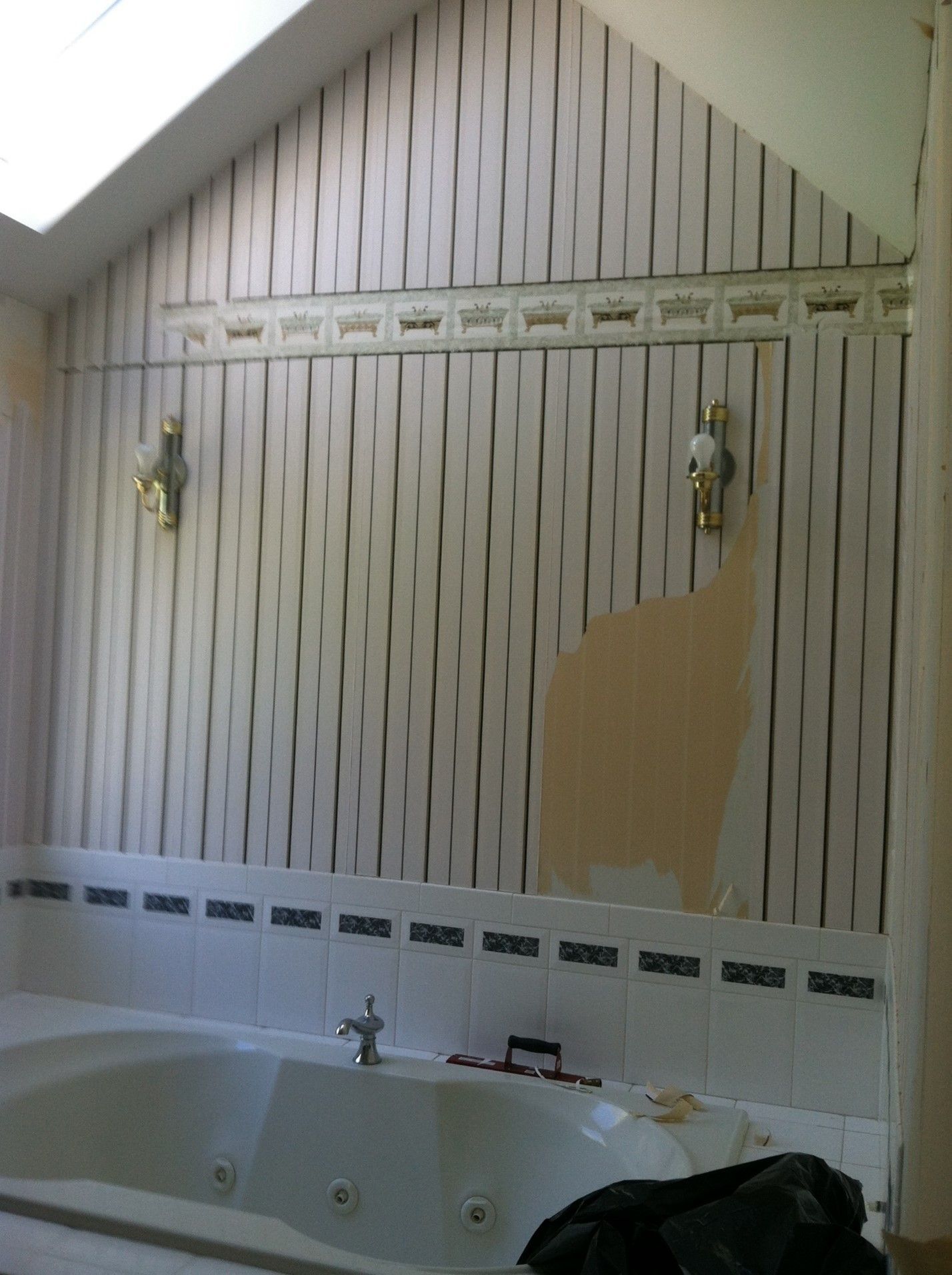 A bathroom with striped wallpaper and a jacuzzi tub
