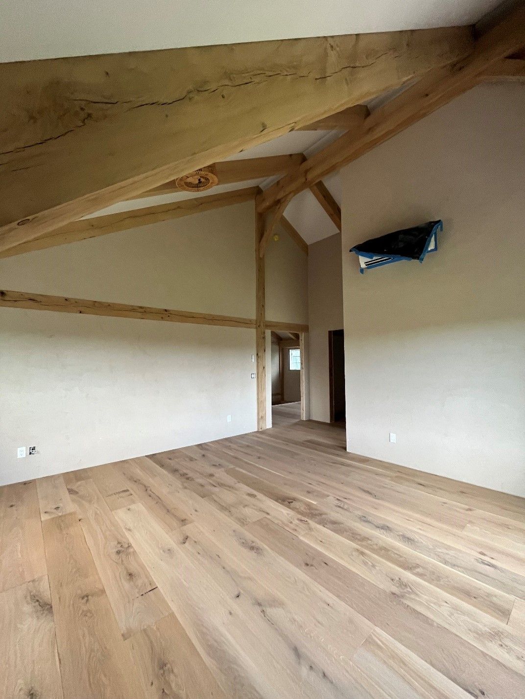 An empty room with wooden floors and white walls