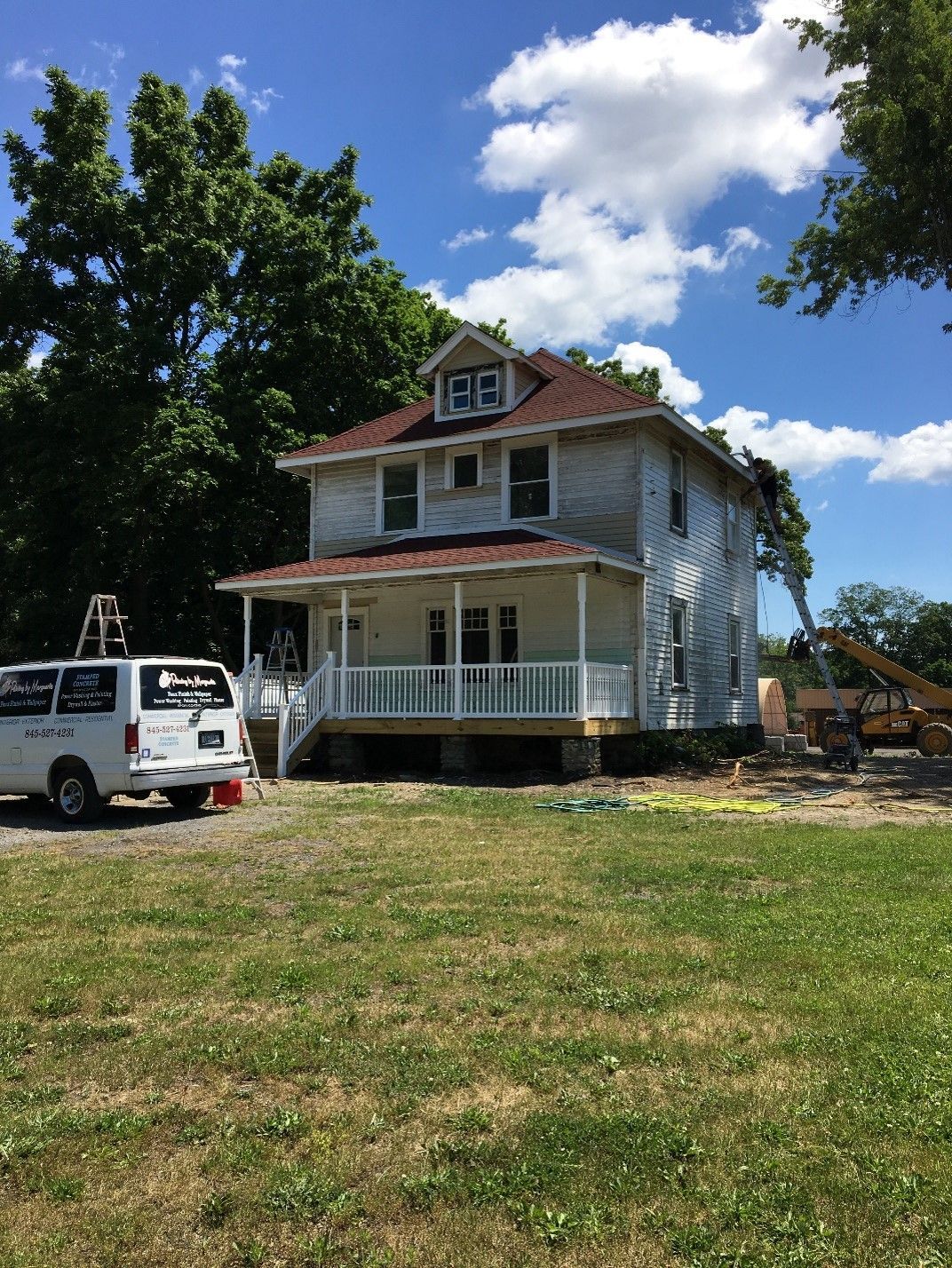 A white van is parked in front of a white house.