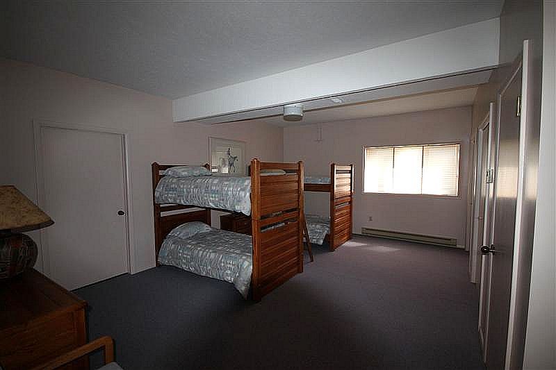 A bedroom with two bunk beds and a lamp.