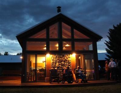A group of people sitting outside of a house at night