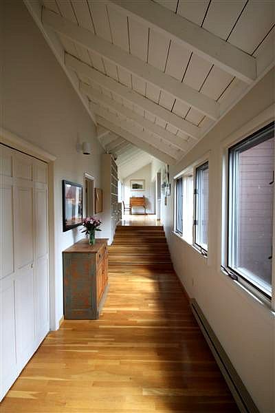 A long hallway with wooden floors and a white ceiling