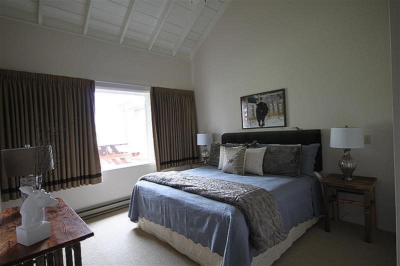 A bedroom with a king size bed and two lamps