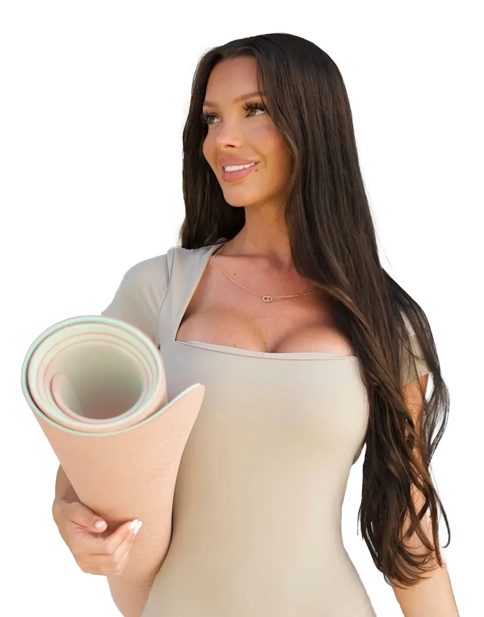 A woman is holding a yoga mat in her hands.