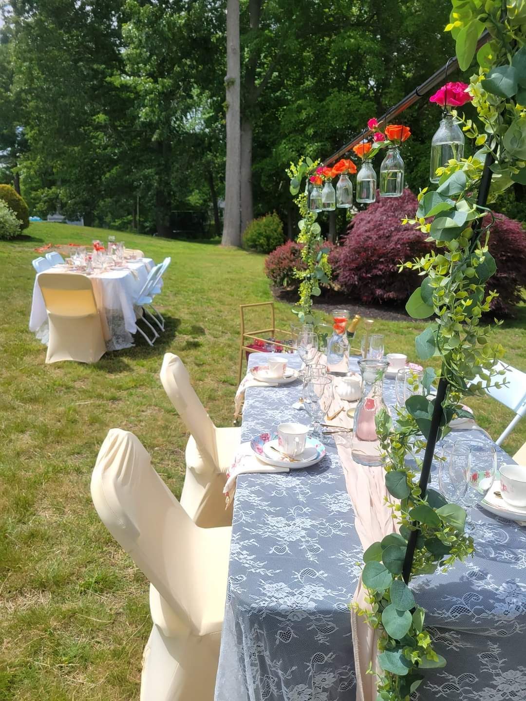 A table and chairs are set up in the grass for a party.