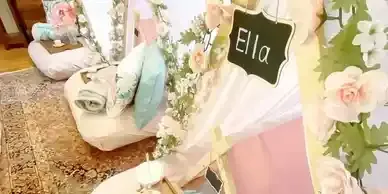 A teepee is decorated with flowers and a sign that says `` ella ''.