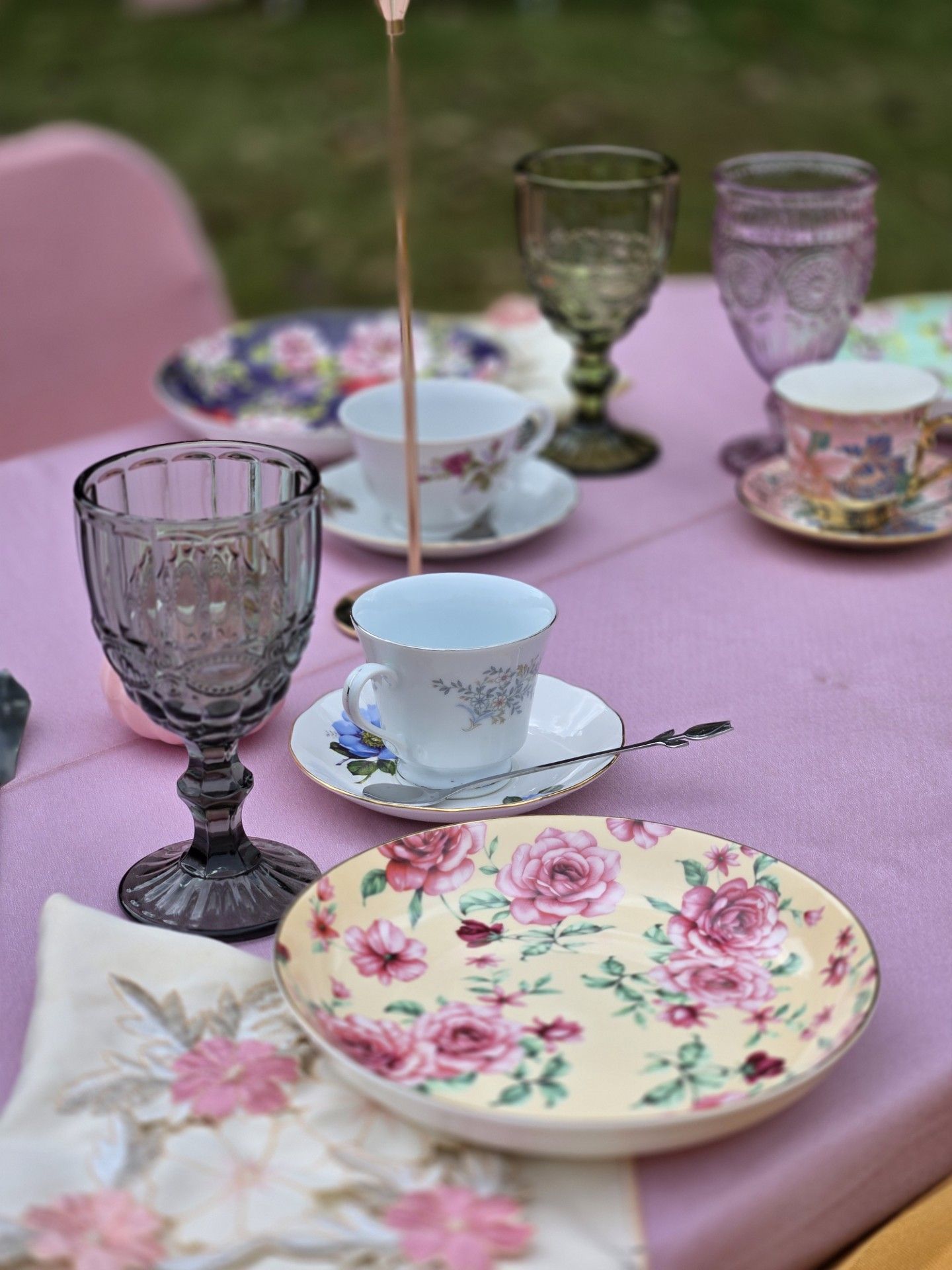 A table with plates , cups and glasses on it.