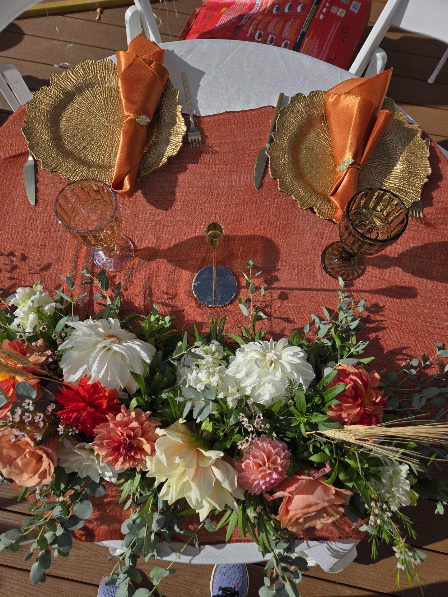 A table with plates , napkins , glasses and flowers on it.