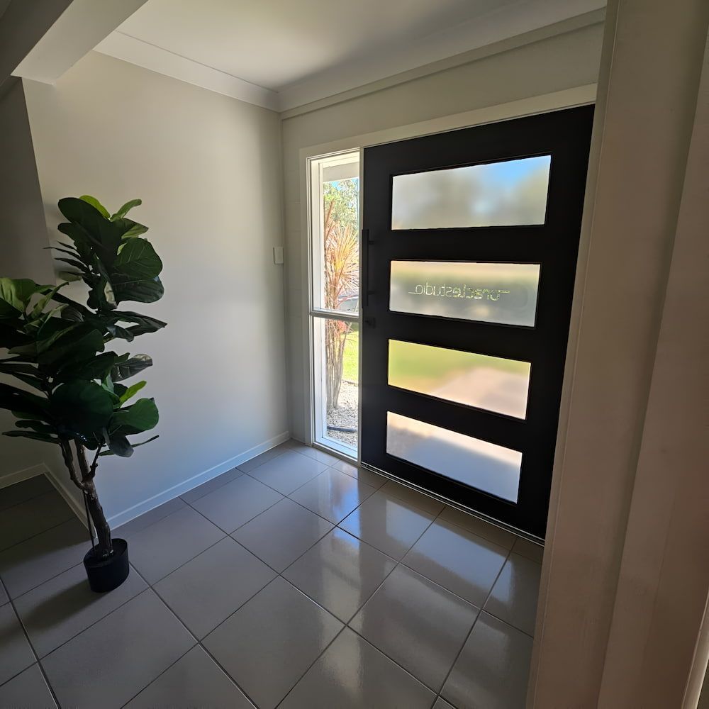 A Door With A Plant In Front Of It And A Window — Glittering Cleaning Service In Townsville, QLD