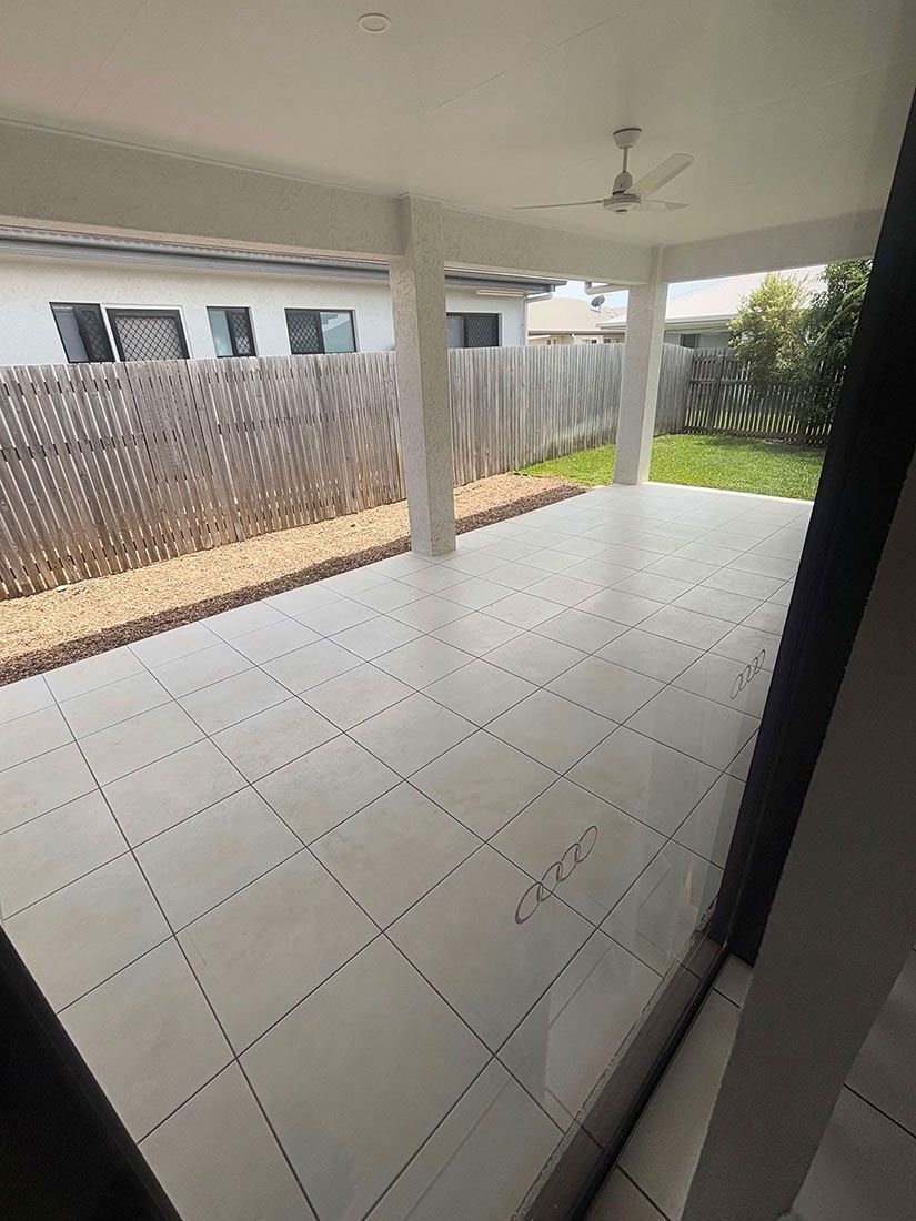 A Large Patio With a Ceiling Fan and a Fence in the Background — Glittering Cleaning Service In Townsville, QLD