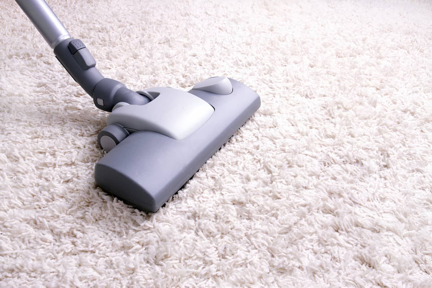 A Vacuum Cleaner Is Being Used To Clean A White Carpet — Glittering Cleaning Service In Townsville, QLD