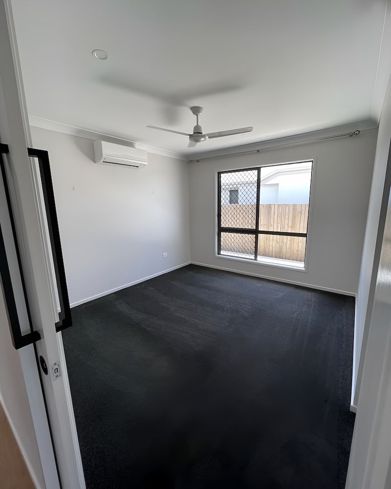 An Empty Room With A Ceiling Fan And A Window — Glittering Cleaning Service In Townsville, QLD