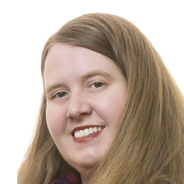 A woman with long brown hair is smiling for the camera