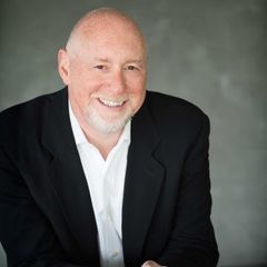 A man in a suit and white shirt is smiling for the camera.