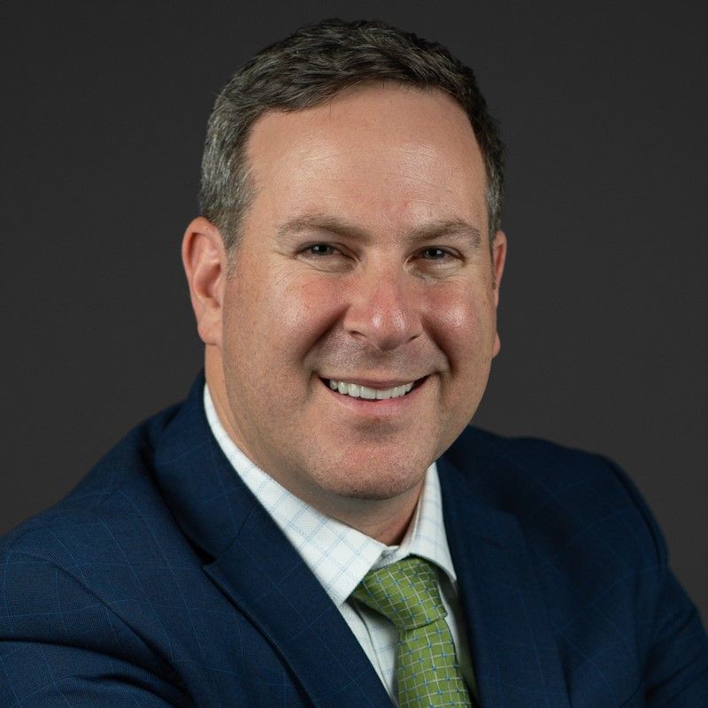 A man in a suit and tie is smiling for the camera.