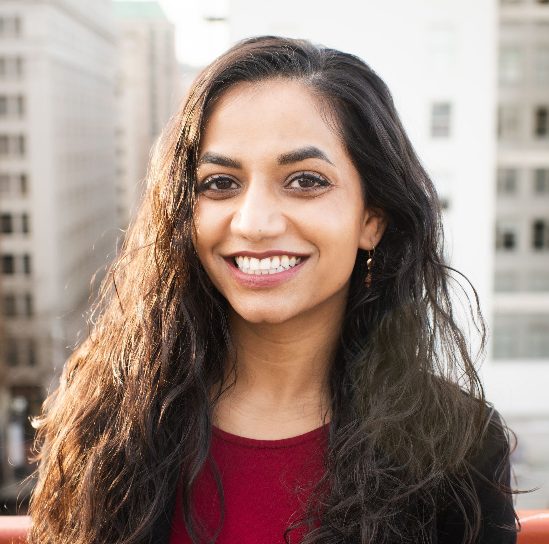 A woman with long hair is smiling for the camera.