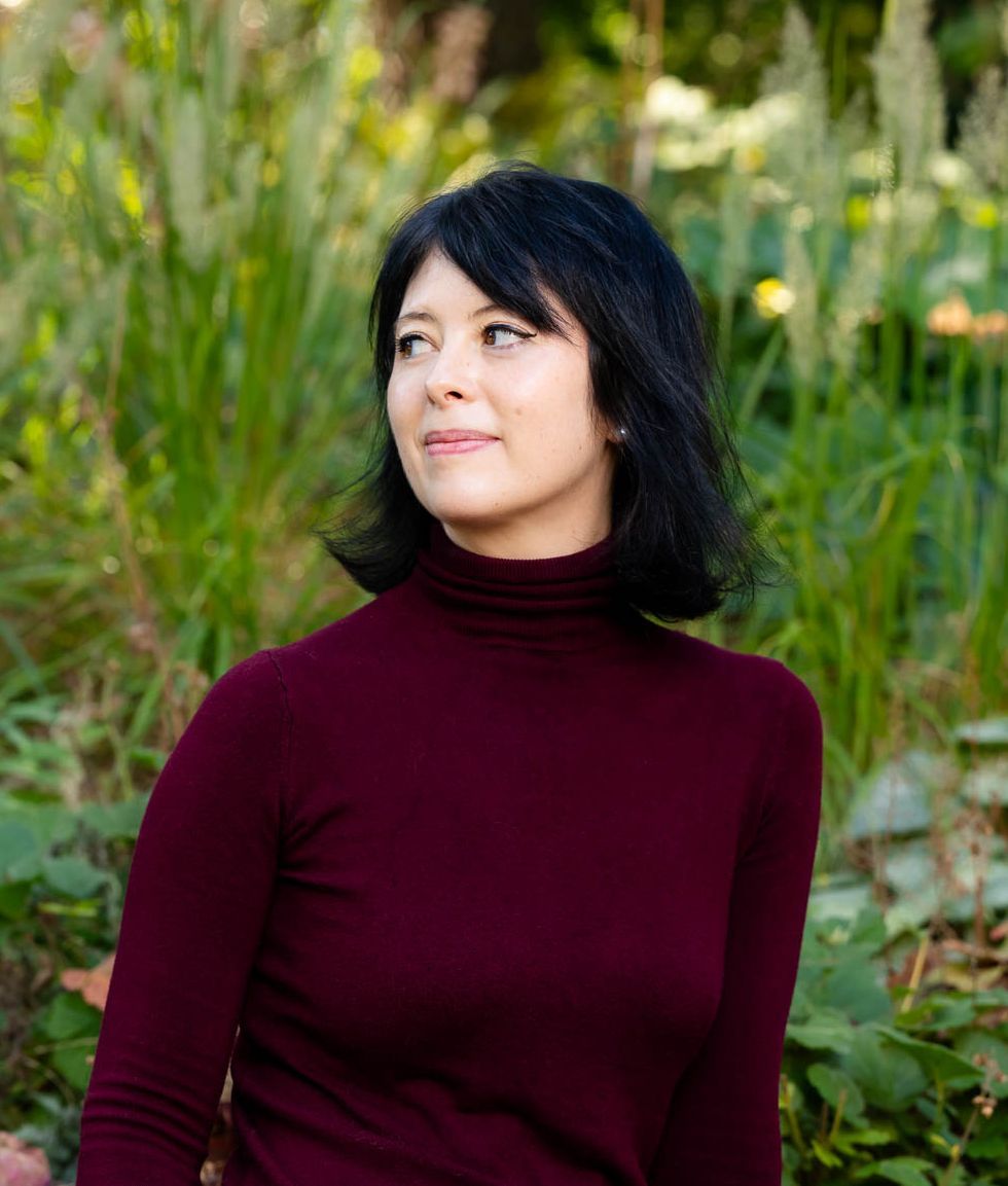 A woman with long brown hair is smiling for the camera