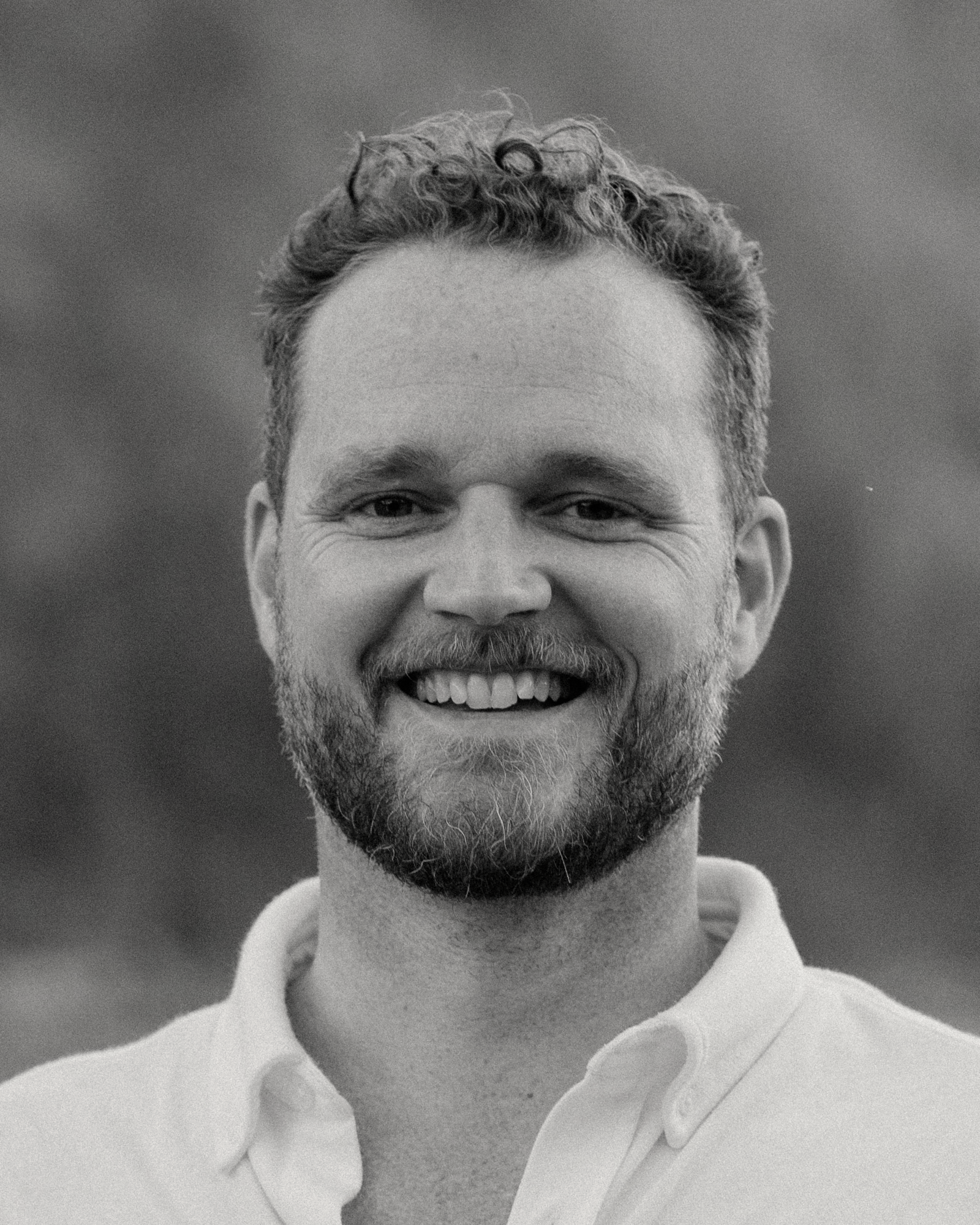 A woman with blonde hair is wearing a green sweater and a blue shirt