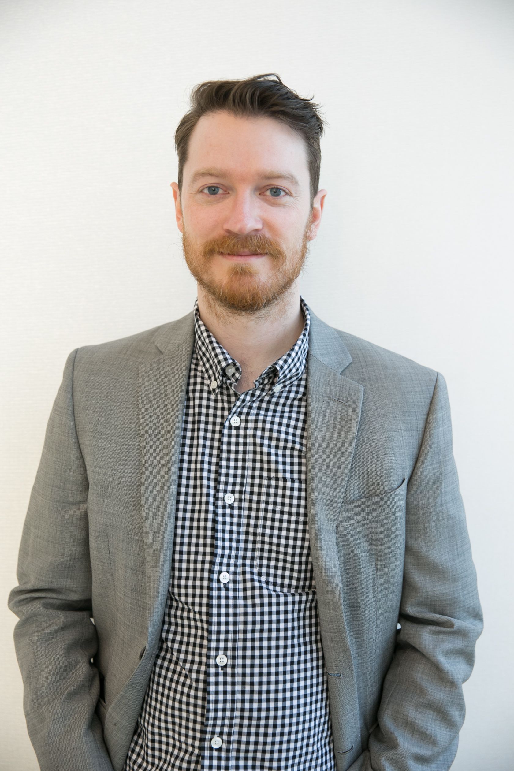 A man wearing glasses is standing in front of a bookshelf filled with books including the slave trade
