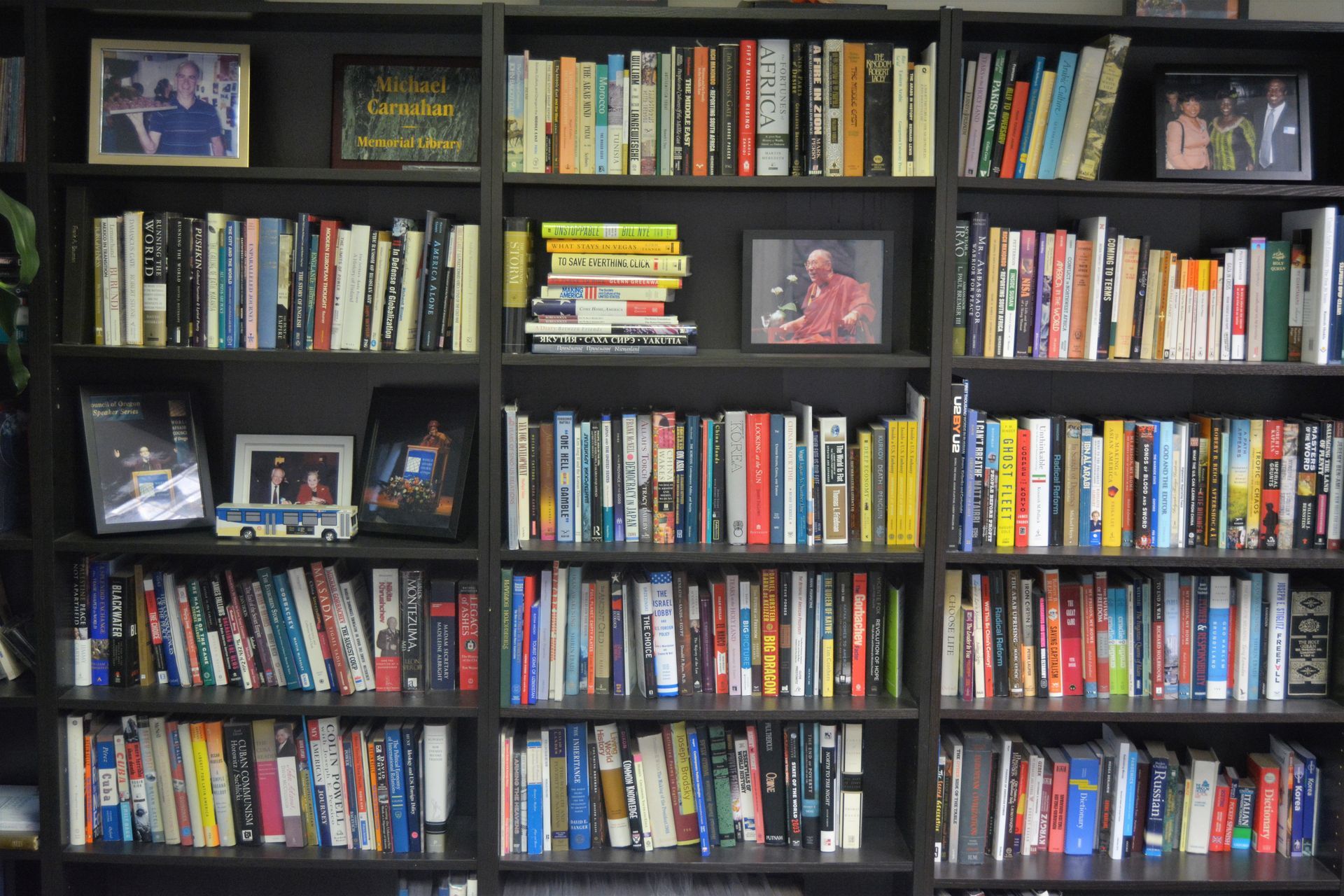 A bookshelf filled with lots of books and pictures