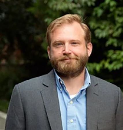 A man in a suit and tie is smiling for the camera.