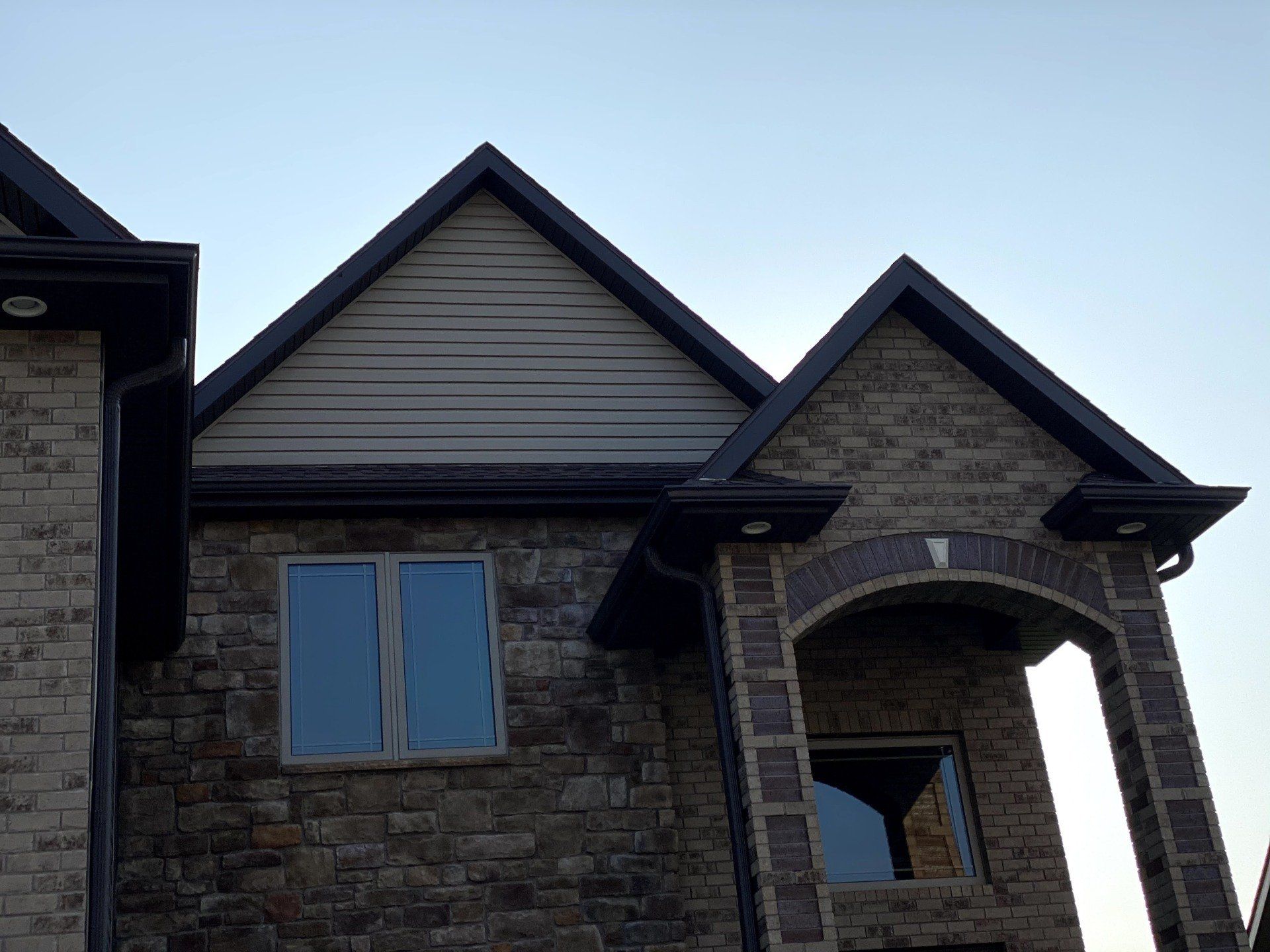A brick house with a triangle shaped roof