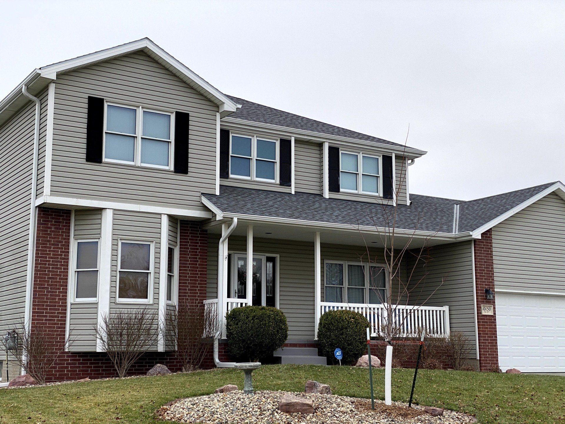 A large house with a porch and a garage