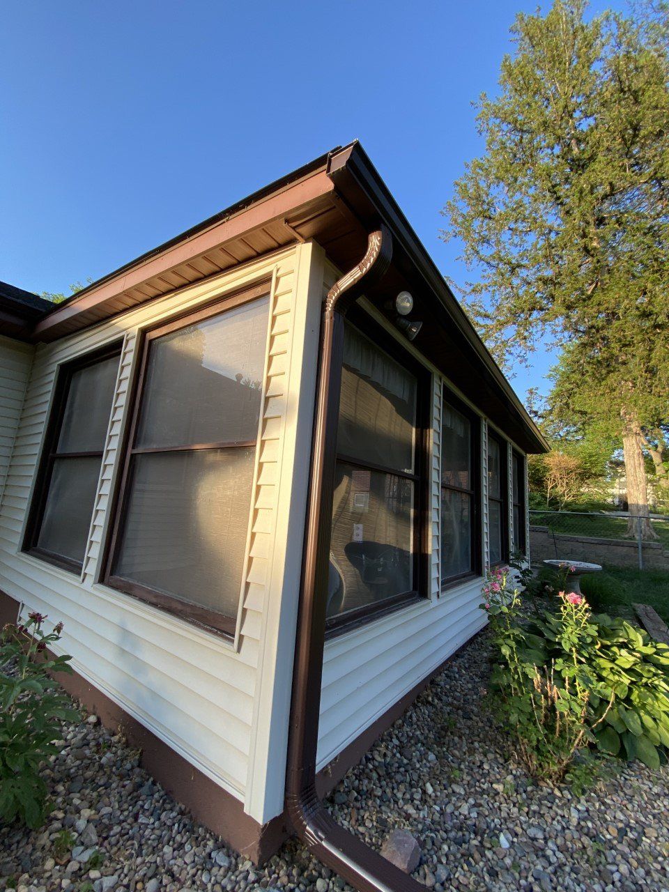 A house with a screened in porch and a brown gutter