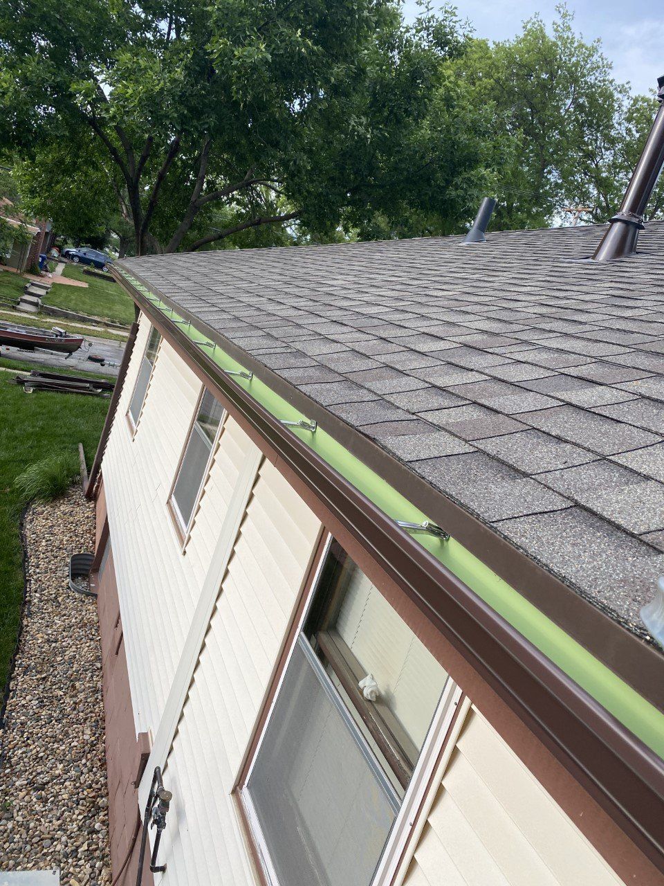 A house with a green gutter on the side of it