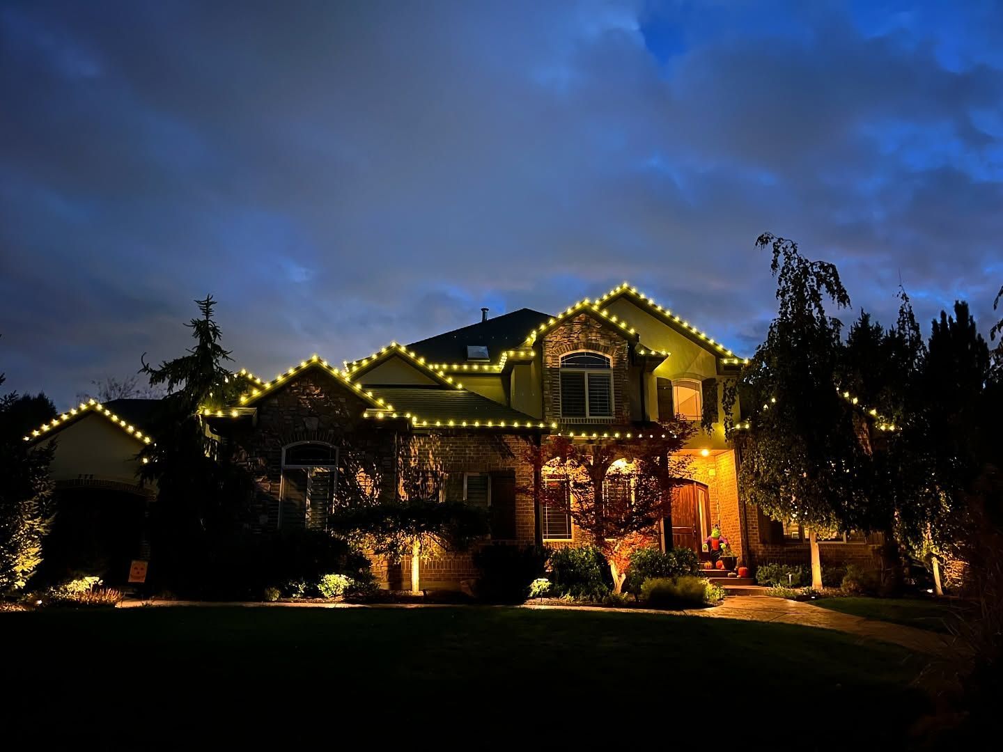 A large house is lit up with christmas lights at night