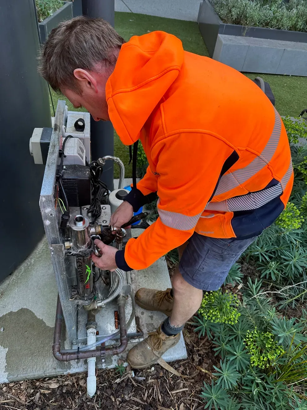 A Tradie Fixing a Rainwater Pump — PUMPtek in Grovedale, VIC