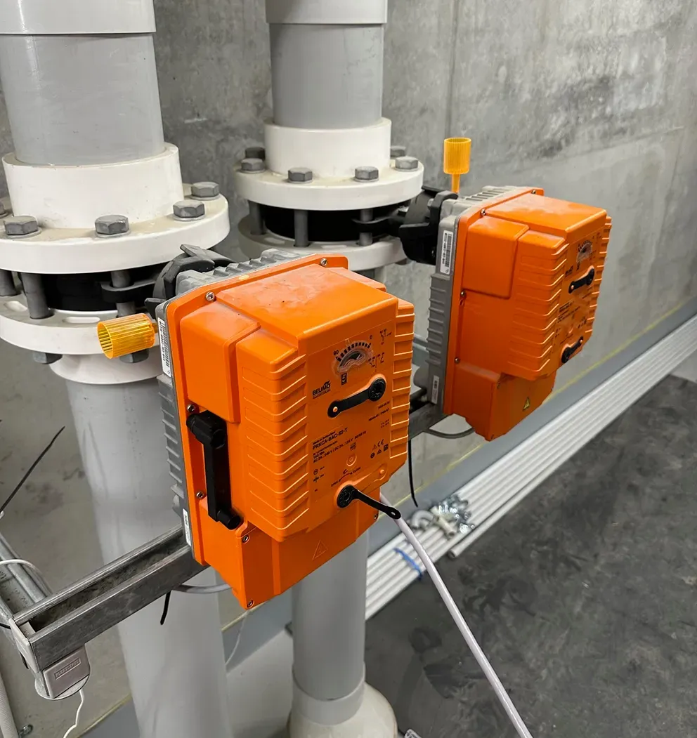 Two orange industrial control boxes mounted on gray pipes in a utility roo  — PUMPtek in Bendigo, VIC