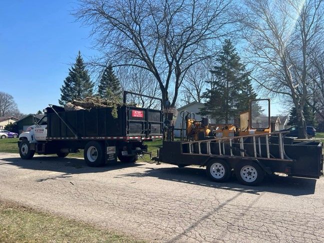 A Truck With a Trailer Is Parked on the Side of the Road — St. Charles, MI — Acorn Tree Service & Landscape Inc