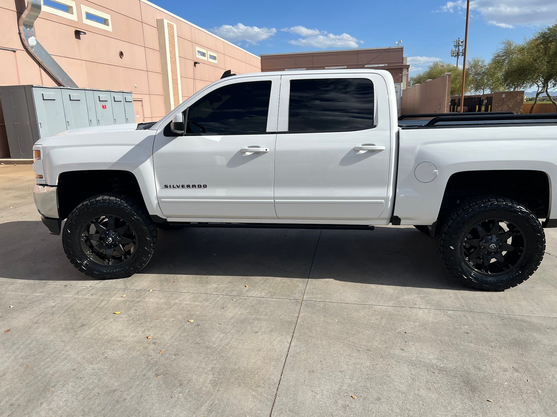 Lifted White Pickup Truck Parked By Shop Building | G & M Motorsports