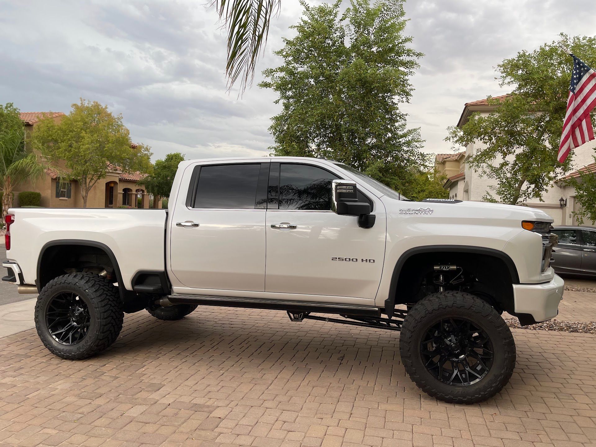 White Lifted Truck With Black Wheels Parked In Driveway | G & M Motorsports