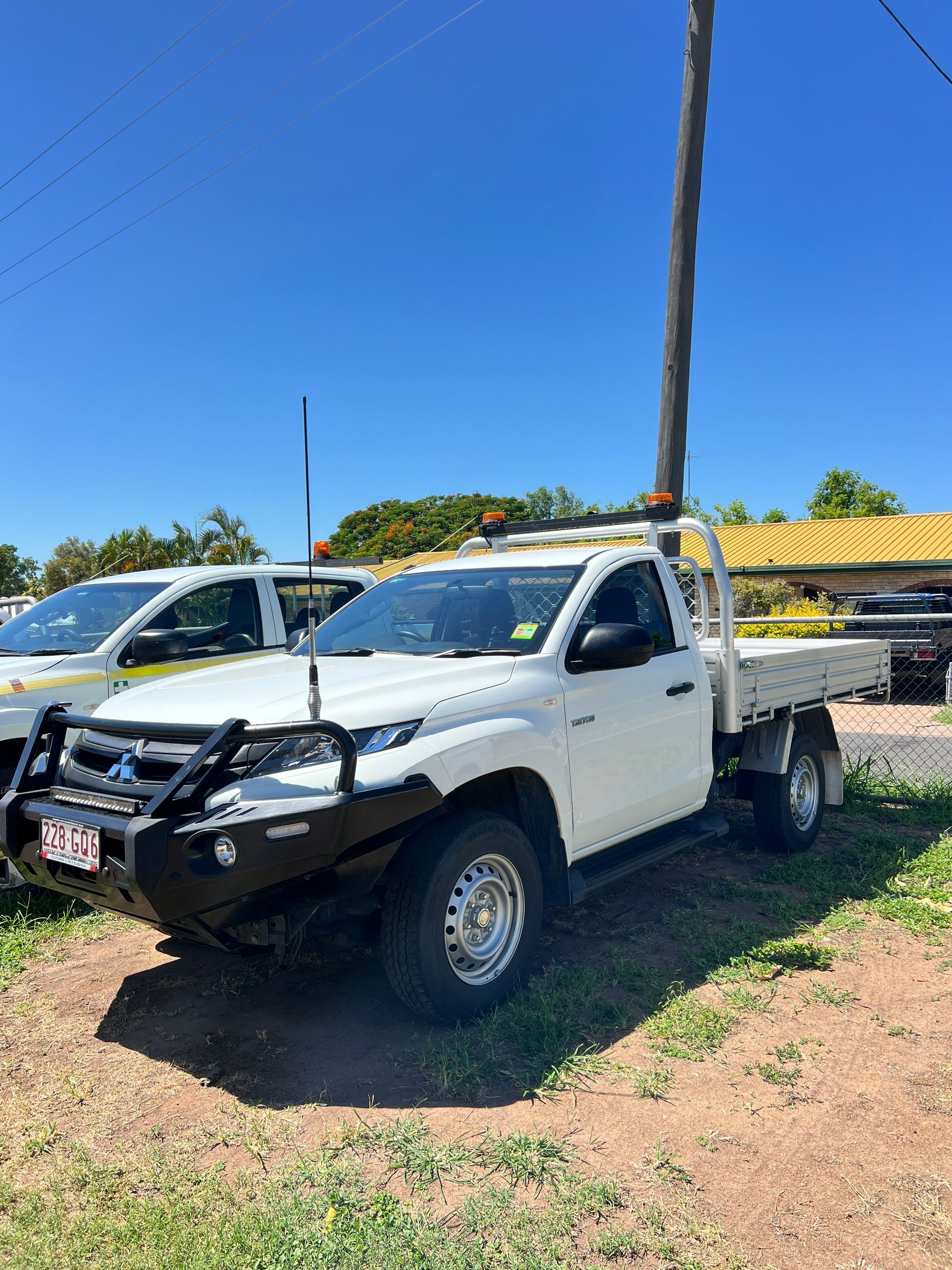 A White Truck is Parked in a Grassy Field Next to a Pole — Locqal Car Truck Trailer Rentals in Emerald, QLD