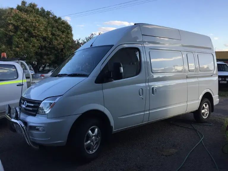 A White Van is Parked in a Parking Lot Next to a Truck — Locqal Car Truck Trailer Rentals in Emerald, QLD