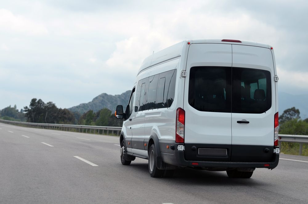 White Mini Bus On The Road — Locqal Car Truck Trailer Rentals in Emerald, QLD